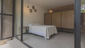 A bedroom with a bed, bedside table, and wardrobe. - Estudio LALO Temozon Norte Mérida (Mérida)