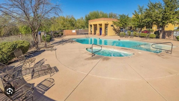 A swimming pool with lounge chairs and a small pavilion.