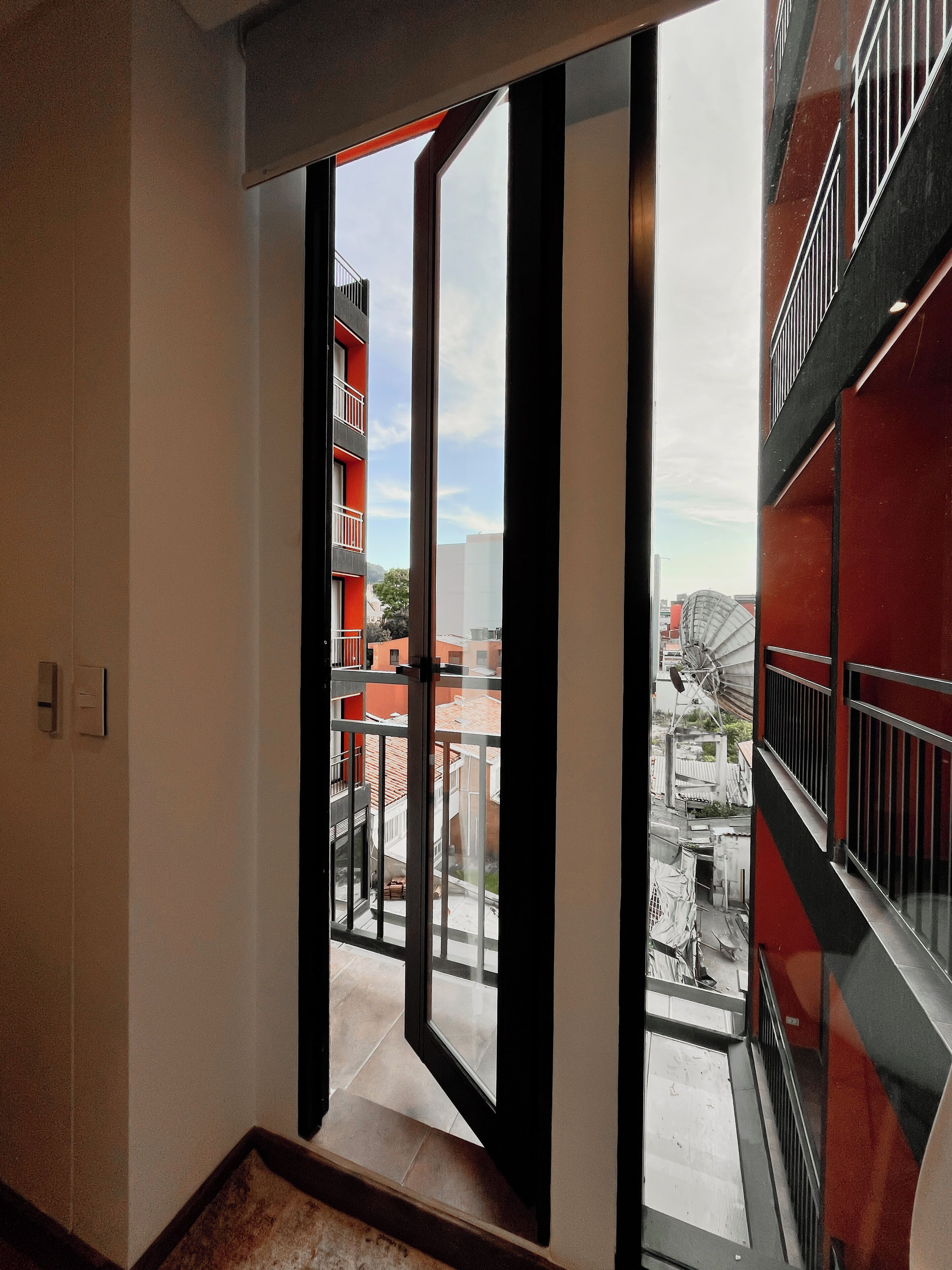 Et moderne interiør med en stor glasdør, der fører ud til en balkon.