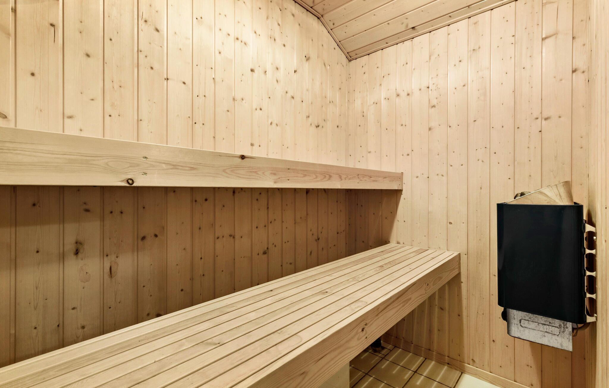 A sauna room with wooden walls and benches.