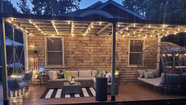 A covered patio area with a wooden deck, a cushioned seating area, and string lights. - Charming house with WiFi and AC in superb Randolph (Randolph)