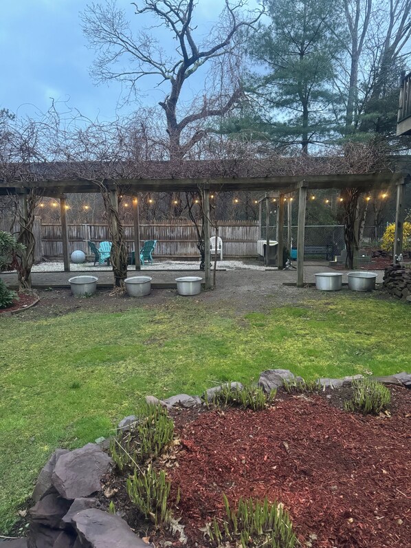 A covered patio area with a pergola, outdoor seating, and a fenced yard. - Charming house with WiFi and AC in superb Randolph (Randolph)