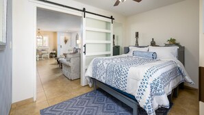 A bedroom with a bed, a ceiling fan, a nightstand, and a bedside table. - Casa Rosa-4th Floor Gorgeous Condo (Phoenix, Arizona)