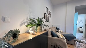 Una sala de estar moderna con un sofá, una mesa de centro y una planta en maceta.
