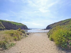 A sandy beach with cliffs on either side and a clear sky. - Nolton Haven - Giddy Puffin (Haverfordwest)