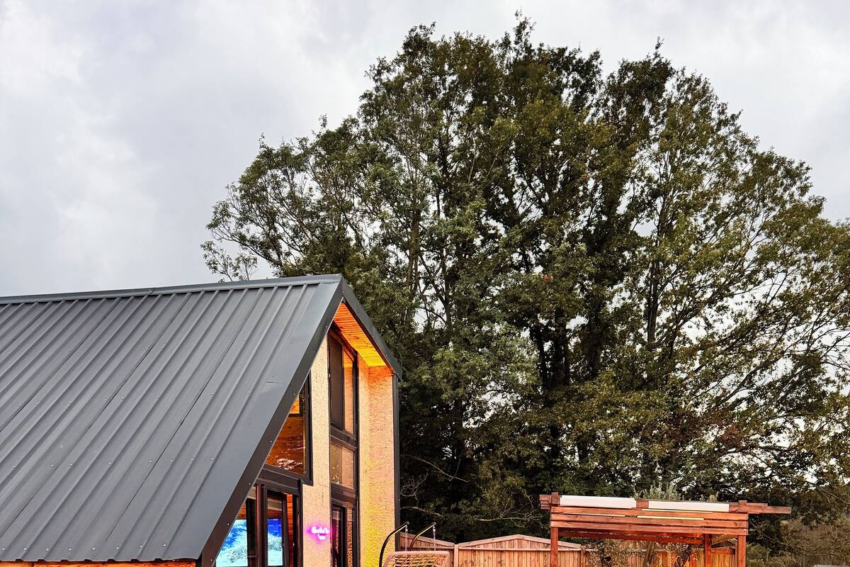 A modern house with a swimming pool, wooden deck, and outdoor seating area.