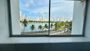 A view from a window overlooking a city skyline with tall buildings, palm trees, and a body of water. - Apartaestudio Con Encanto en Cartagena (Cartagena)