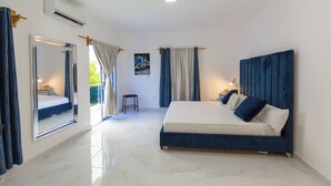 Un dormitorio con una cama grande, un espejo y una ventana con cortinas.