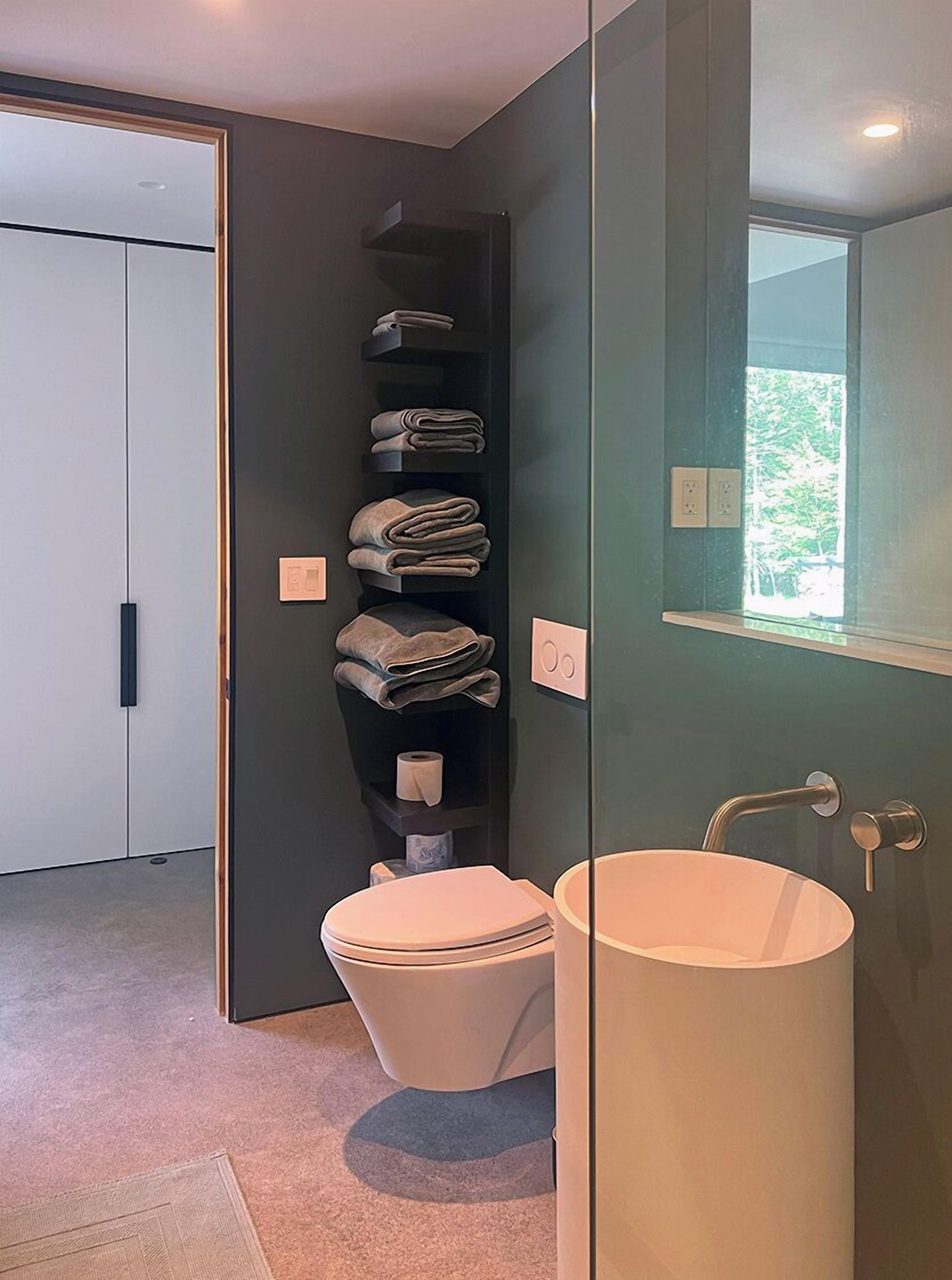 Un baño moderno con inodoro, lavamanos y toallero.