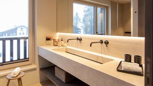 Un bagno moderno con un ampio specchio, due lavabi e una finestra che offre vista all'esterno.