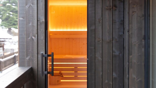 Una porta in legno con un vetro, una maniglia in metallo e un pavimento di legno.