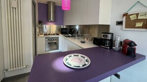 A modern kitchen with a purple countertop, stainless steel appliances, and a pink pendant light. - Charming Tuscan Home With Pool Near Lucca (Lucca)