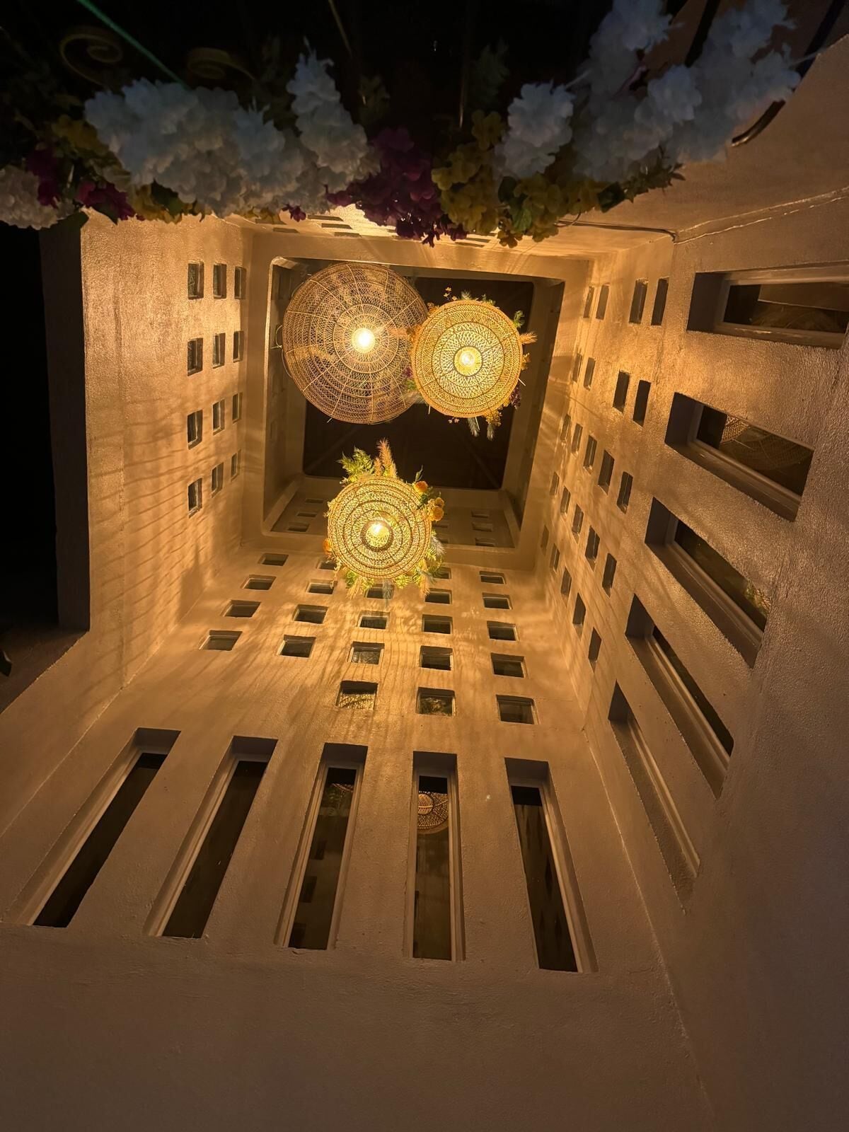 A modern building with a unique geometric design, featuring circular skylights and a central decorative element.