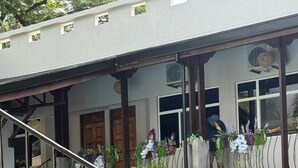 A residential building with a swimming pool, a staircase, and a balcony with potted plants. - Parti Gras Hotel & Villas en Potrero (Tempate)