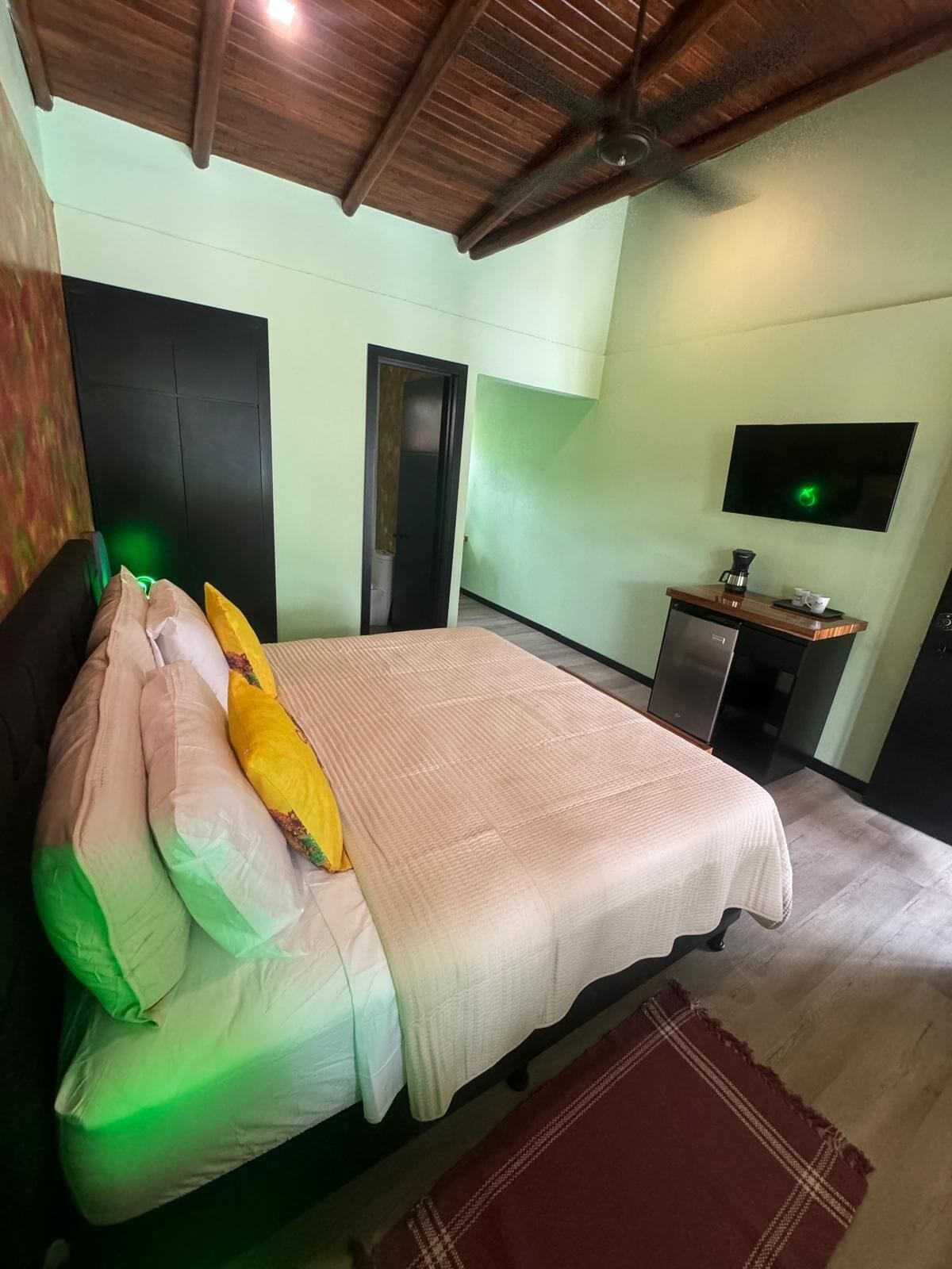 Ein Schlafzimmer mit Bett, Fernseher und einer Küchenzeile.