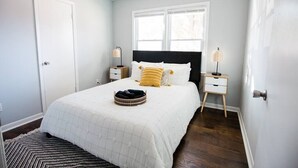 A bedroom with a bed, bedside tables, a window, and a ceiling fan. - HOT TUB, Fenced in Yard, Pet Friendly, Game room (Fayetteville)