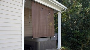 Un espace extérieur aménagé, abrité et doté d’un jacuzzi, de guirlandes lumineuses et d’un paravent en bois pour plus d’intimité.