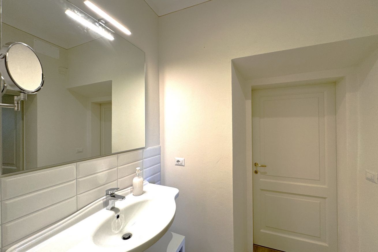 Ein Badezimmer mit Waschbecken, Spiegel und Tür.