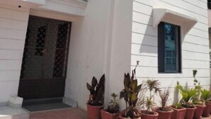 Un edificio de varios pisos con revestimiento blanco y ventanas grandes.