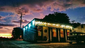 A building with a sign reading "OMALLEY & SON" and "Stouts & Porter" indicating it is a bar or pub.
