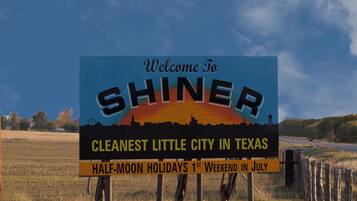 Welkomstbord voor Shiner, Texas, dat de netheid en feestdagen in halve maan benadrukt.