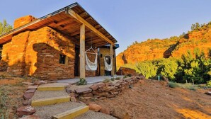A rustic stone building with a wooden roof and a covered porch.
