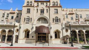 A historic building with a central entrance, arched windows, and a decorative facade.