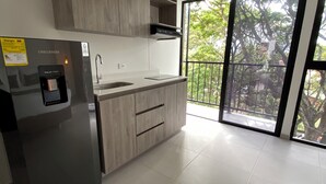 A modern kitchen with a built-in refrigerator, a sink, and wooden cabinets. - Hotel ECO 44 (Medellín)