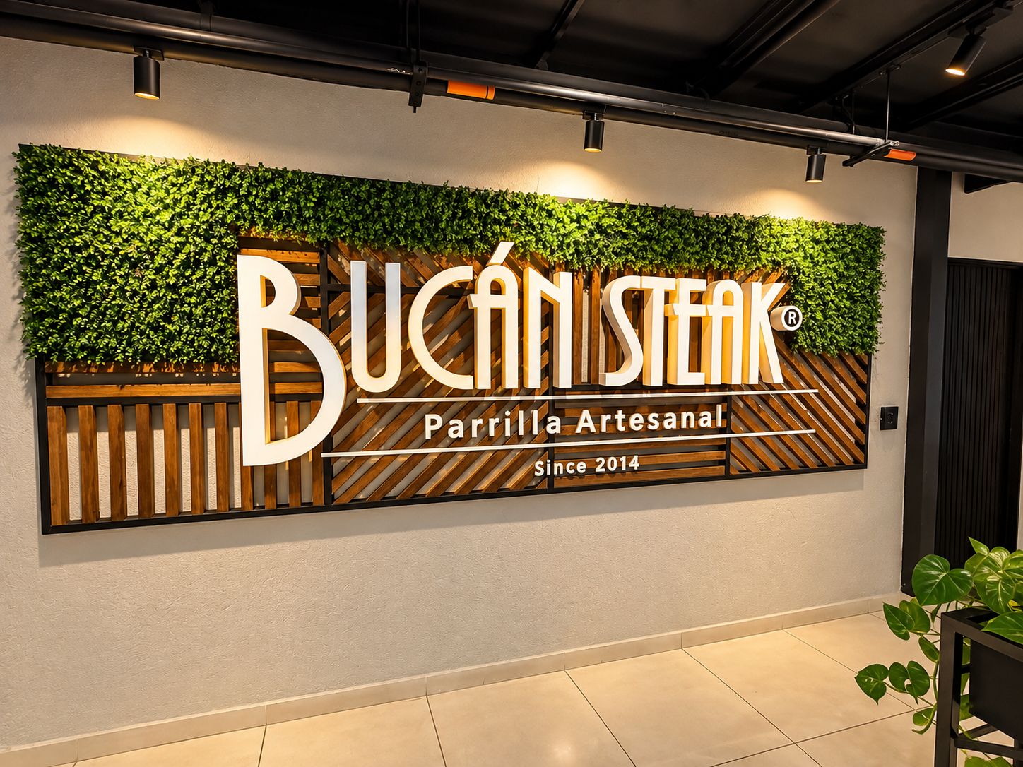A wall with a sign for Bucan Steak, Parrilla Artesanal, established since 2014.