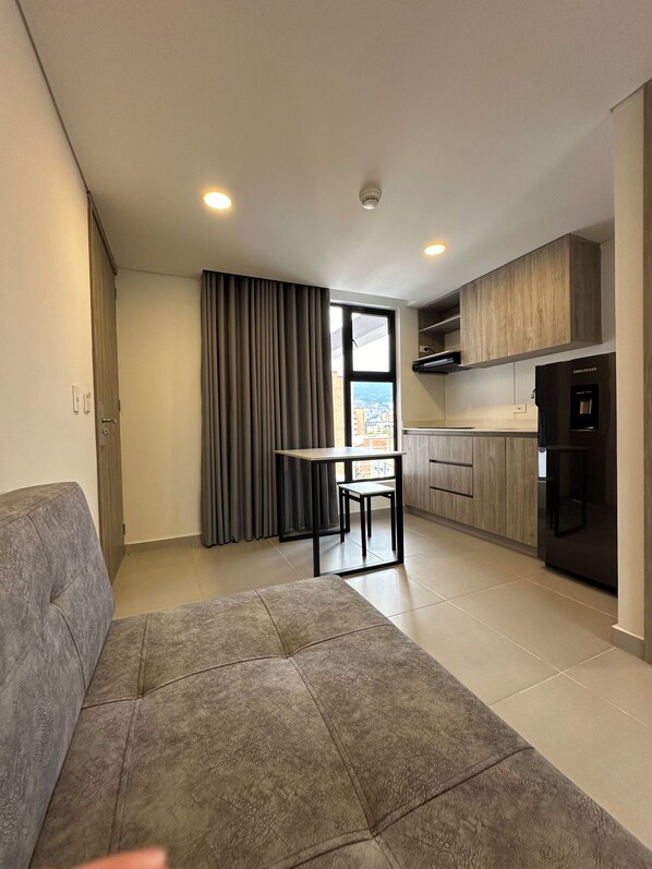 A modern apartment with a living area, a dining table, and a kitchen. - Hotel ECO 44 (Medellín)