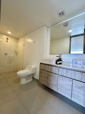 A modern bathroom with a toilet, a sink, and a mirror. - Hotel ECO 44 (Medellín)
