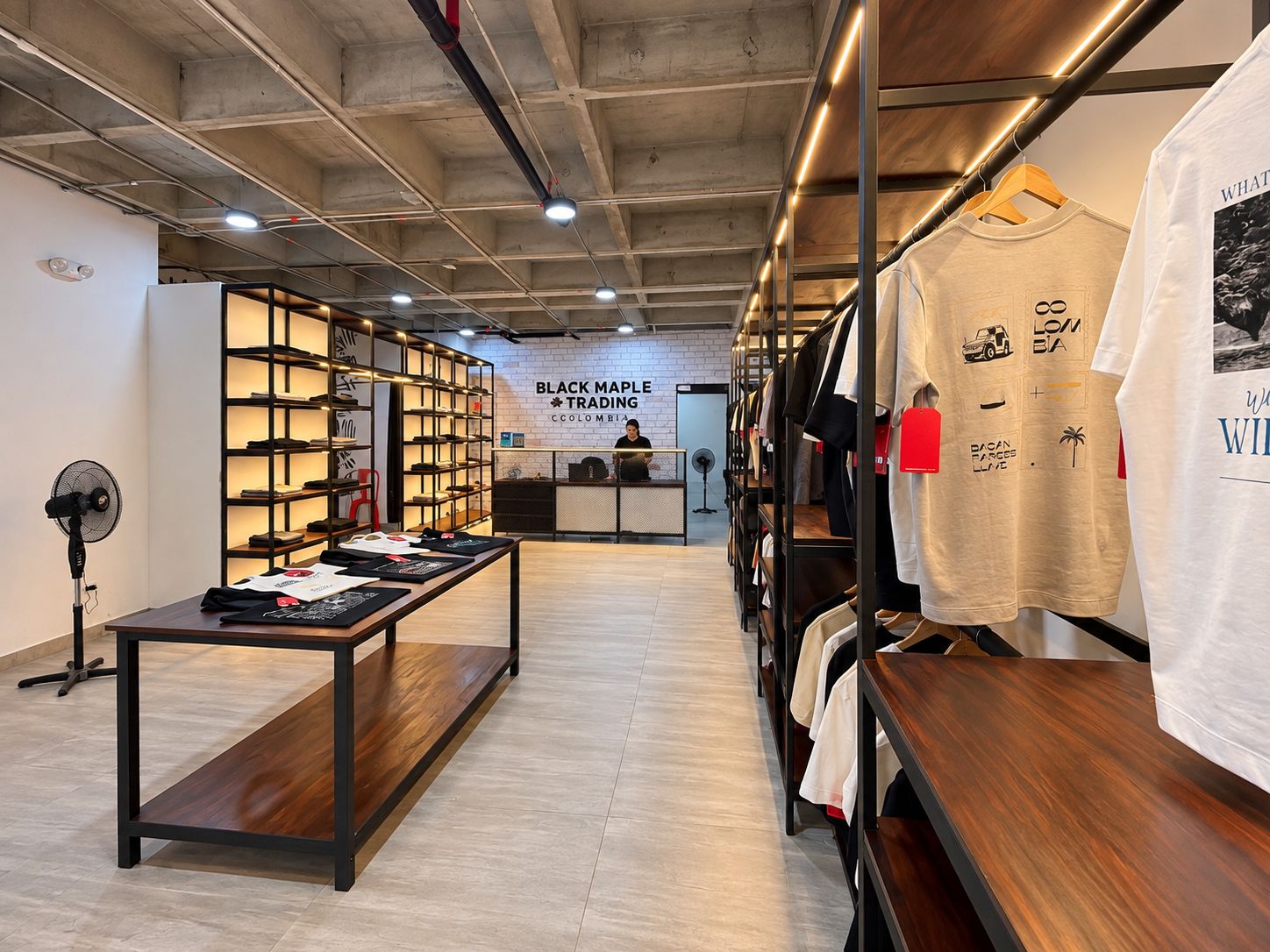 A retail space with a wooden table, shelves with shoes, and a sign for Black Maple Trading.