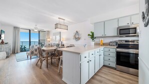 Une cuisine moderne avec des meubles blancs, un îlot central et des appareils électroménagers en acier inoxydable.