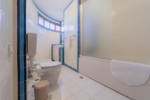 A bathroom with a toilet, sink, and bathtub.