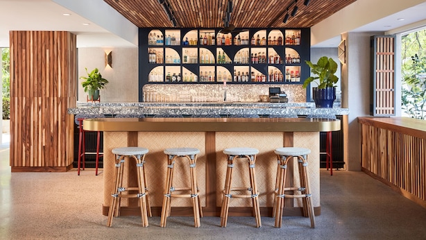 A modern bar area with a wooden ceiling, a bar counter, and four wicker stools. - Classic Room with King Bed – Design-Centric Space (Honolulu)