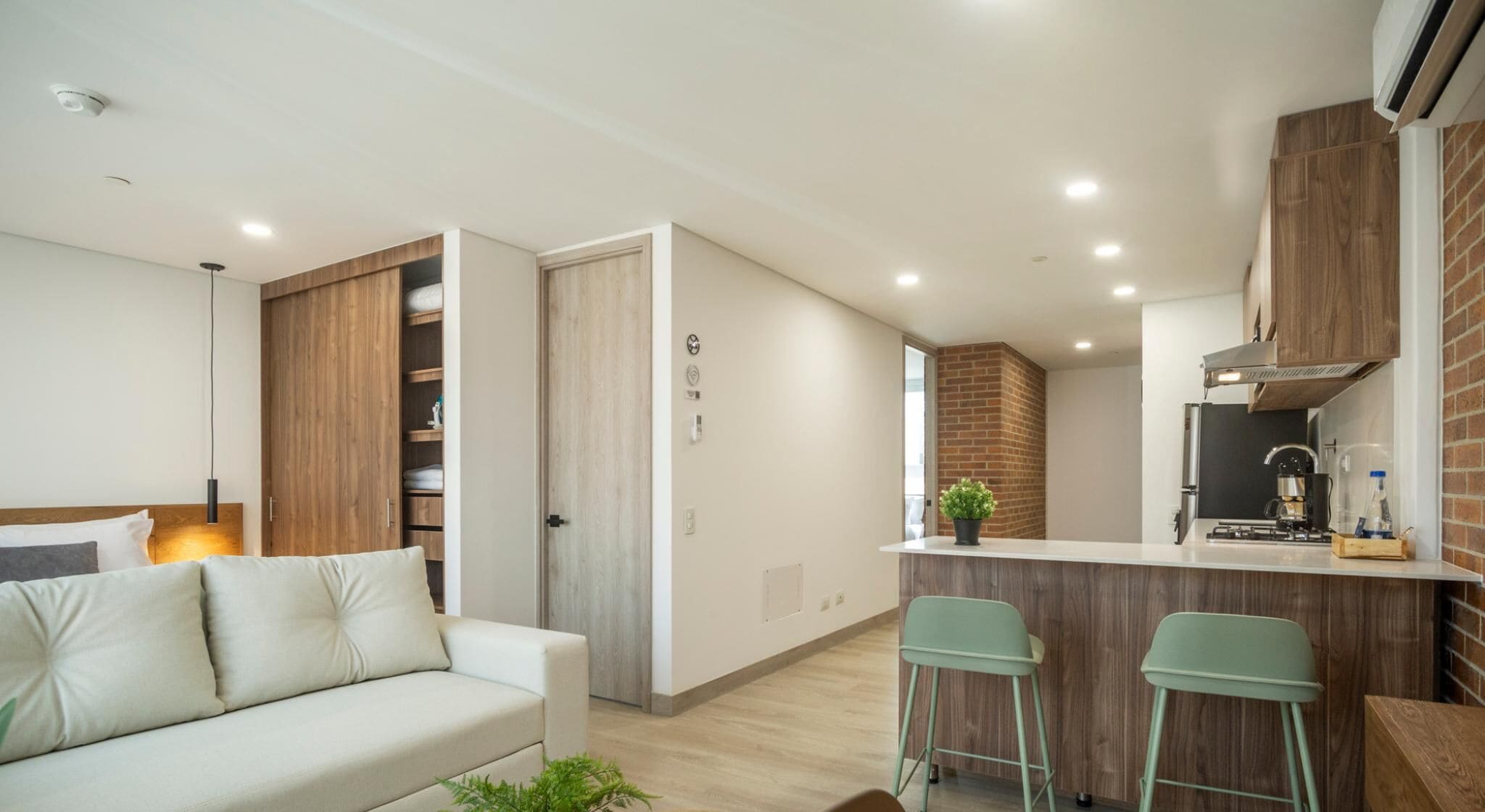 A modern apartment with a living area, kitchenette, and a small bar area.