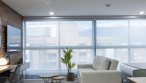 Deluxe Apartment | Living area | 55-inch Smart TV with cable channels, streaming services