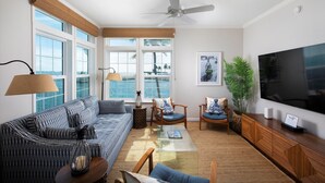 A living room with a sofa, chairs, a coffee table, a TV, and large windows overlooking the ocean. - Post Card Point #319 - Ocean Views! (Cudjoe Key)
