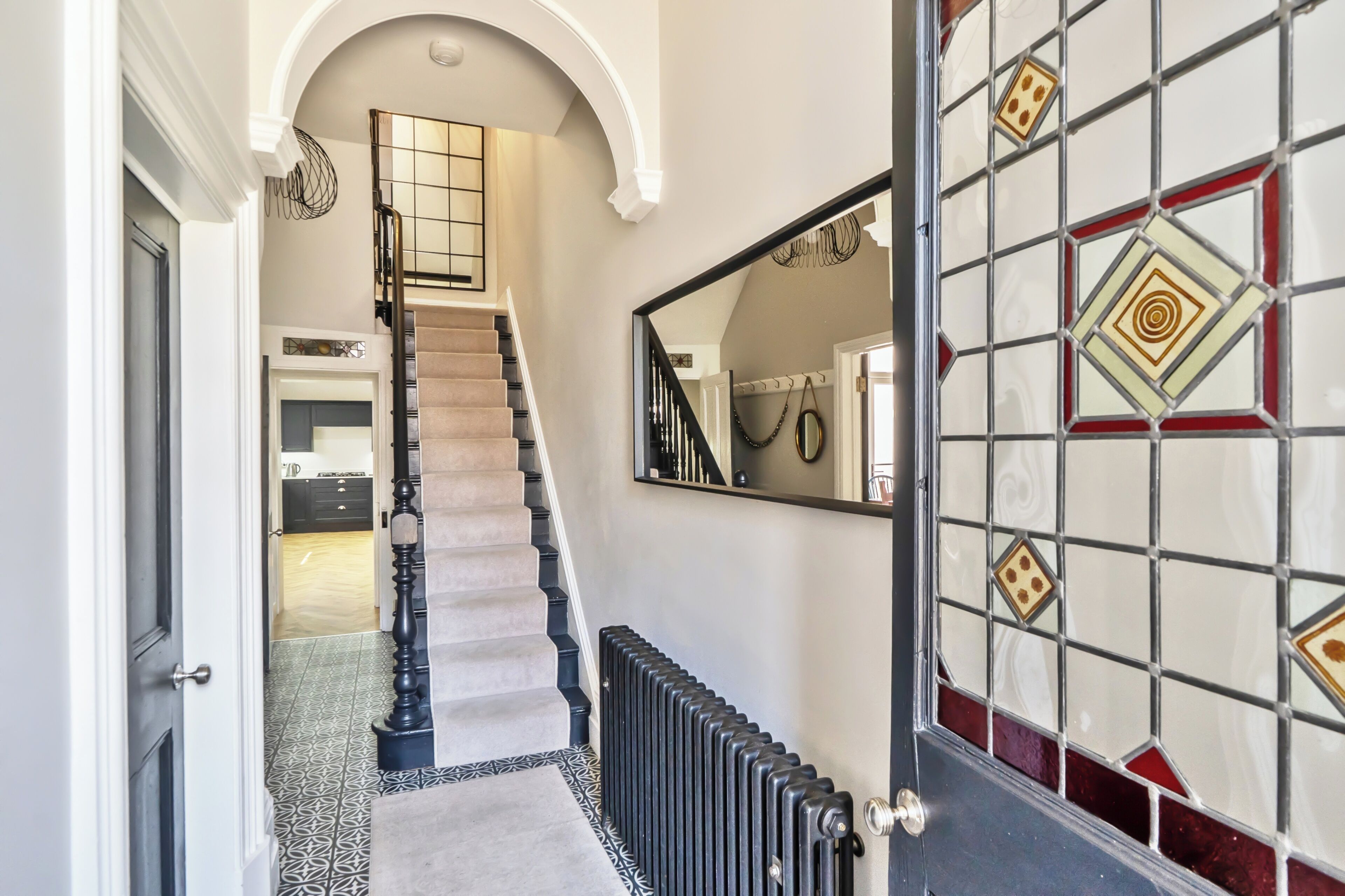 A staircase leading to a landing with a radiator below.