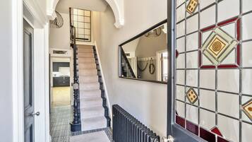 A staircase leading to a landing with a radiator below.