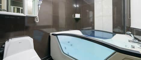 A modern bathroom with a bathtub, a toilet, and a shower.