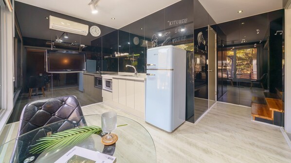 A modern kitchen with a refrigerator, sink, and dining area. - Hongcheon Inmylife Dokche Pension (Hongcheon)