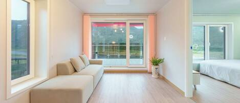 A modern interior with a sofa, a potted plant, and a bed.
