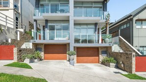 Un moderno edificio residencial de varios pisos con garaje, balcón y escalera.
