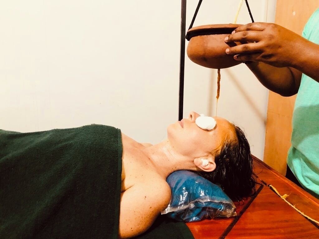 A person lying on a massage table receiving a treatment.