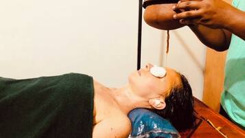 A person lying on a massage table receiving a treatment.