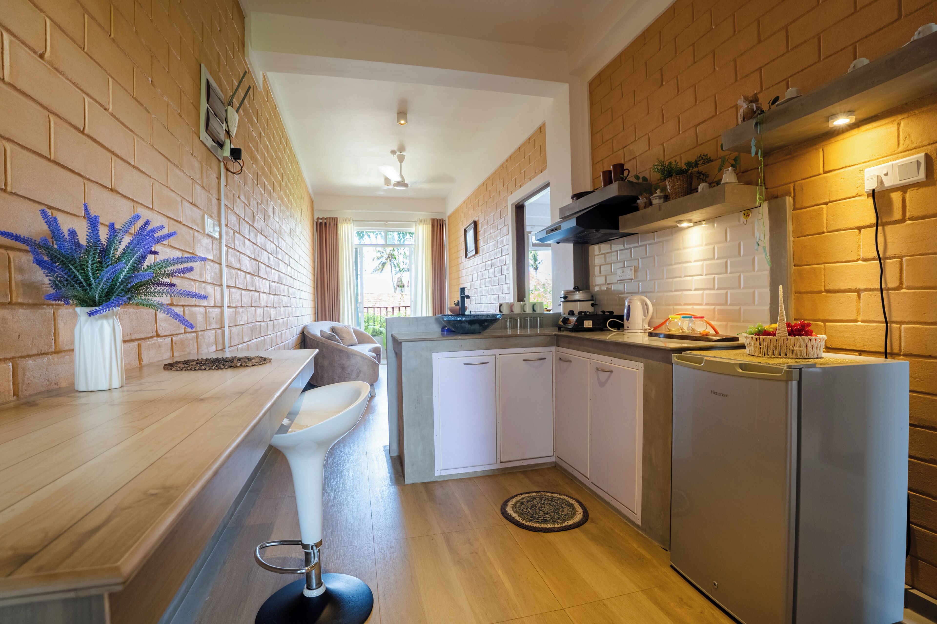 A kitchen with a wooden countertop, white cabinets, a built-in oven, and a refrigerator.