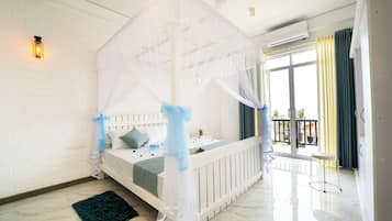 Un dormitorio con cama con dosel, un balcón con vistas y una pared de ladrillo blanco.