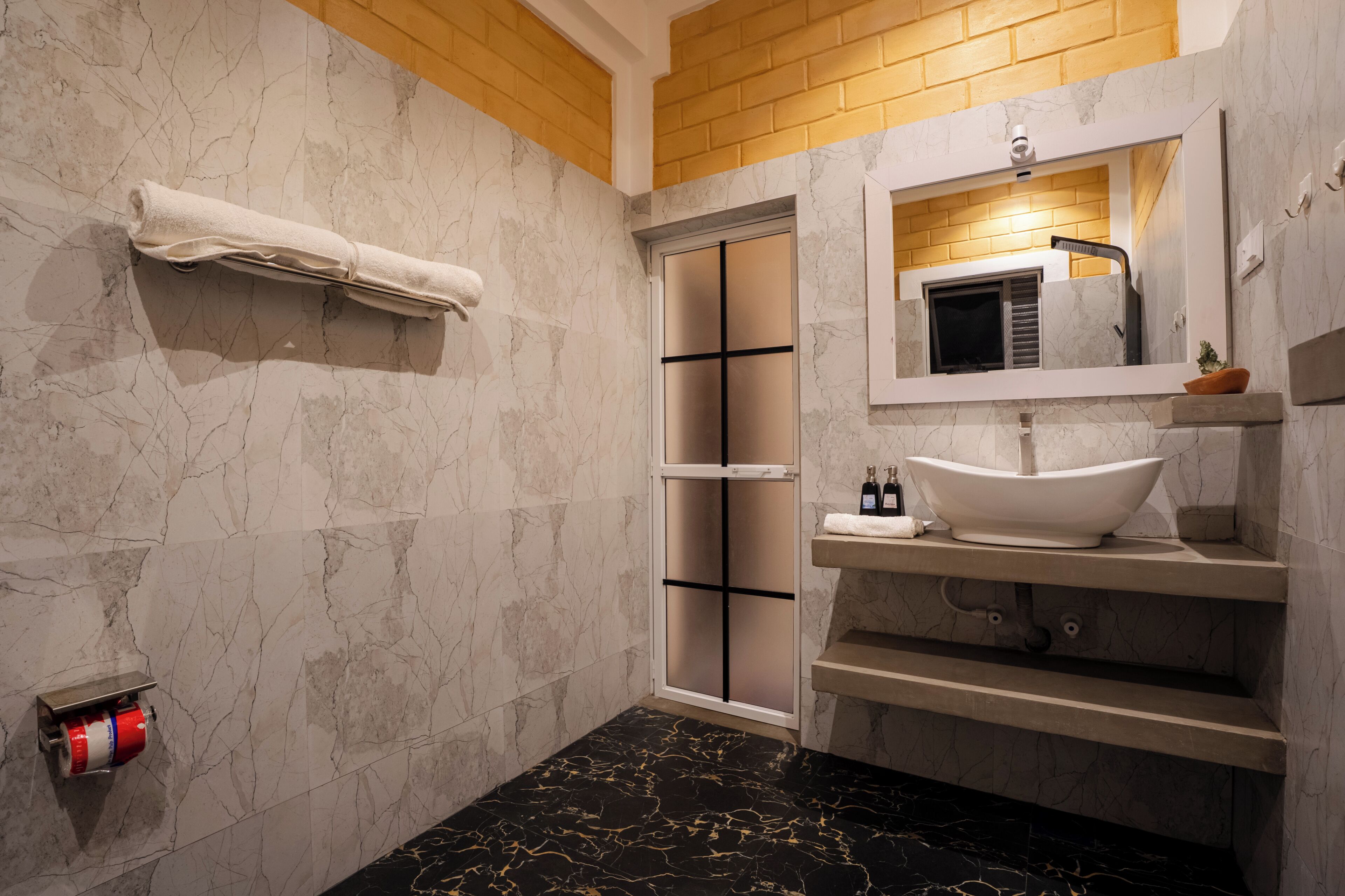 A bathroom with a marble floor, a white sink, a towel rack, and a mirror.