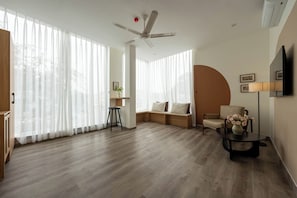Executive Suite, City View | Living area | 55-inch flat-screen TV with cable channels - JOY.ur Home (Ninh Bình)